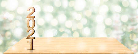 New year 2021 white wood number (3d rendering) on wooden table at blur abstract green christmas tree...