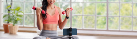 asian trainer woman live streaming on social media about wellness exercise at home.Influrencer marketing trainning course online.new normal fitness classの写真素材