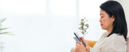 asian woman shopping online with mobile and credit cart payment when order food online at home.digital lifestyle.Mockup sapce banner for display of content to advertise online.の写真素材