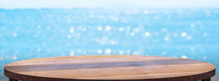 Empty round wood table with summer blue sea blur background.copy space for display of product on online media advertiseの写真素材