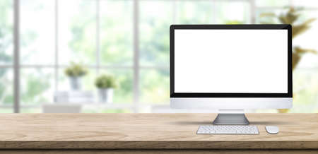 Desktop computer blank screen mockup on wooden table with blur window garden at home.banner space for product display advertising online mediaの写真素材