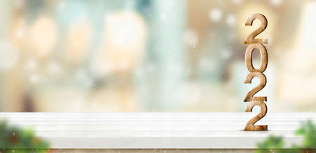 Happy New year 2022 snowing(3d rendering) on brown wood table at blur abstract bokeh light home background with blur leaf foreground,Mock up banner for display of product,holiday celebrationの写真素材