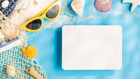 summer sunlight concept.blank paper card on beach accessory on blue sea backgroundの写真素材