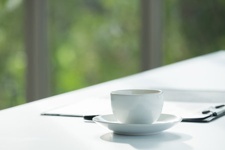 Close up white coffee cup with business contract paper on meeting room table at office.business agreement partnership conceptの写真素材