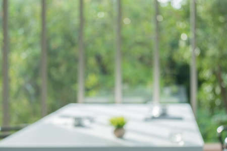 Blur meeting room table in office background with see through window to tree in garden in morning with no people.buisness backdropの写真素材