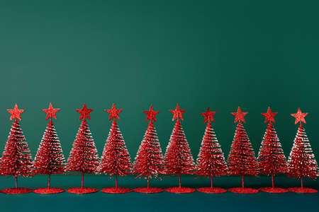 christmas tree red color with star pine tree group on green background with spaceの写真素材