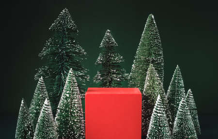 christmas tree group and red vivid product display block on green background.の写真素材