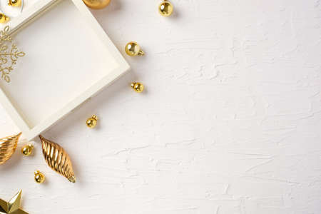 Christmas white picture frame and bauble,gift box,star decoration ornament on white concrete tableの写真素材