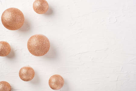 Christmas gold bauble ball decoration on white pastel table backgroundの写真素材