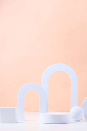 Geometric pedestal block on white table and pastel peach background.mockup for display productの写真素材