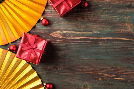Christmas red gift box and golden fan decoration on table wood backgroundの写真素材