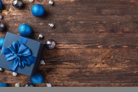 Christmas blue gift box and silver bauble decoration ornament on wood table backgroundの写真素材