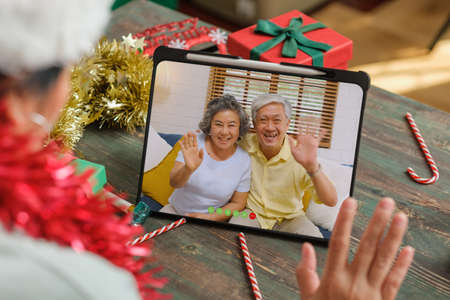 Christmas and new year  video call with famliy with tablet together at homeの写真素材
