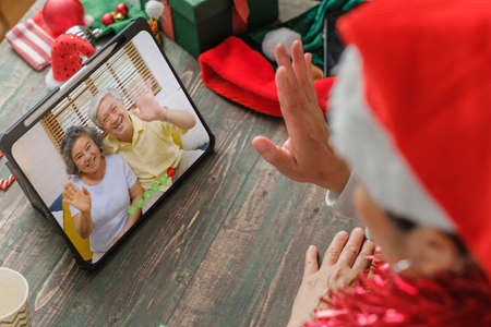 Christmas and new year  video call with famliy with tablet together at homeの写真素材