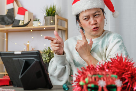 asian woman celebrate new year and christmas party with tablet video call friends at homeの写真素材