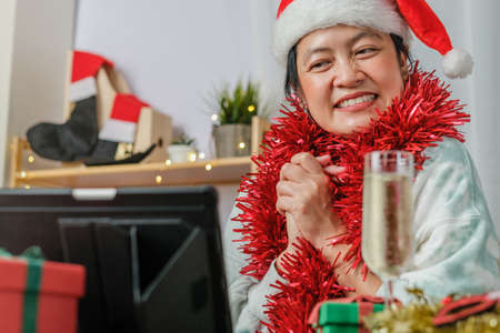 asian woman toasting champagne celebrate new year and Christmas party video call friends at homeの写真素材