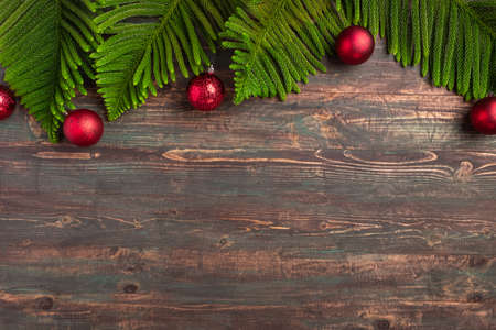 Christmas pine leaf with bauble decoration on wooden tableの写真素材