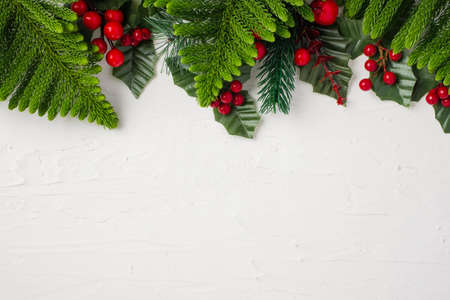 christmas pine leaf and mistletoe on white paster concerte tableの写真素材