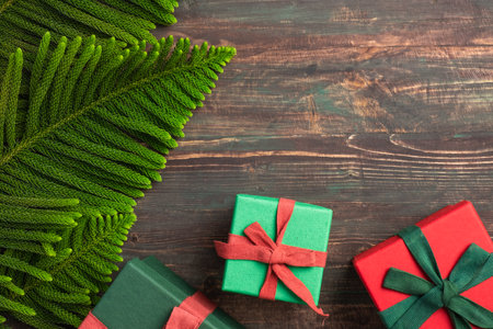 Christmas colorful gift box with pine leaf and decoration ornament on wooden tableの写真素材