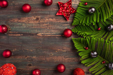 Christmas pine leaf with red bauble decoration on wooden tableの写真素材