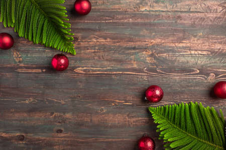 Christmas pine leaf with red bauble decoration on wooden tableの写真素材