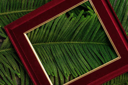 Christmas picture frame with pine leaf and bauble decor on wood tableの写真素材
