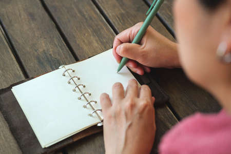 woman writing goal on notebook  at coffee shop outdoor spaceの写真素材