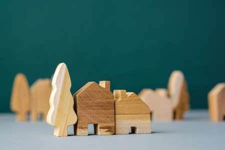 set of wooden house and tree decoration in village on grey floor and green backgroundの写真素材