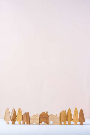 group of wood home toy village shape on white table peach backgroundの写真素材