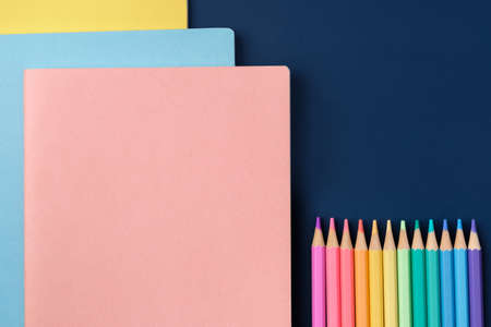 top view pastel notebook with pencil and stationery on navy blue table backgroundの写真素材