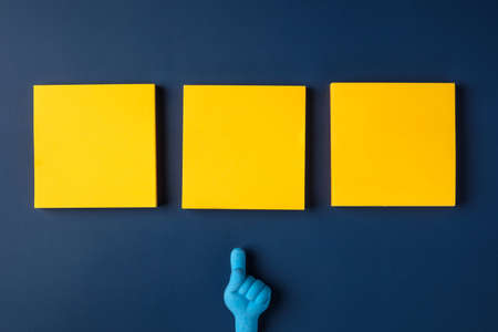 blank yellow sticky note on navy blue table backgroundの写真素材