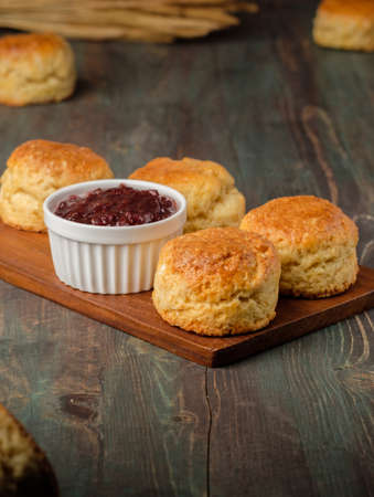 group of scones on wood plate with jam on tableの写真素材
