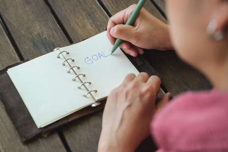 woman writing goal on notebook  at coffee shop outdoor spaceの写真素材
