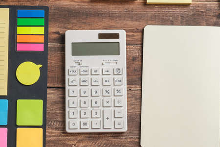 Calculator and note pad planner on wooden office tableの写真素材