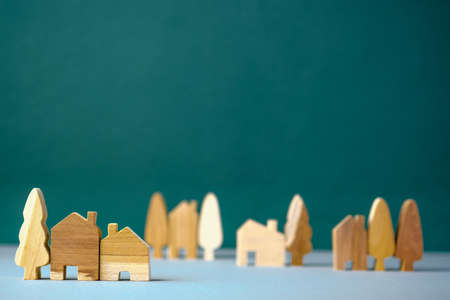 set of wooden house and tree decoration in village on grey floor and green backgroundの写真素材