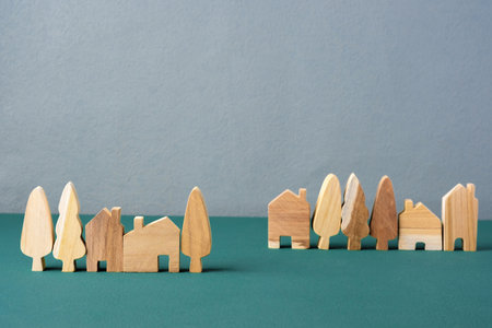 set of wooden house and tree decoration in village on grey floor and green backgroundの写真素材