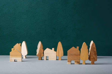 set of wooden house and tree decoration in village on grey floor and green backgroundの写真素材