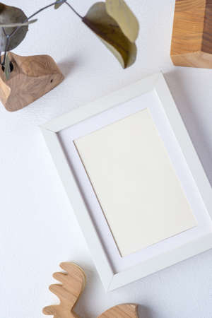 photo frame with eucalyptus branch in wood vase and wood toy on white backgroundの写真素材