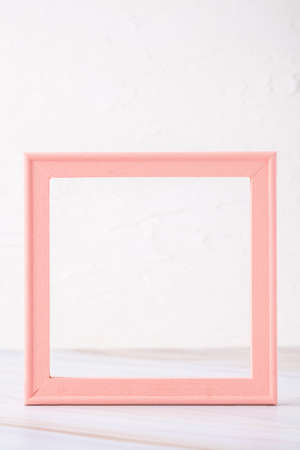 pastel pink picture frame with olive leaf on marble table with concrete wallの写真素材