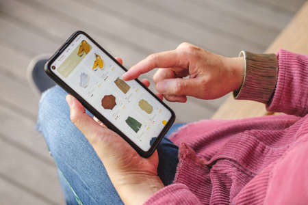 woman shopping online with credit card at coffee shop in outdoor.close up hand holding smartphone