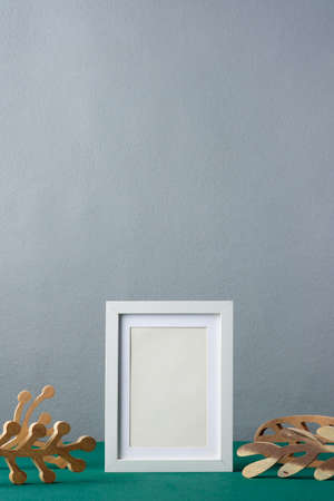 photo frame with wooden leaf on green tableの写真素材