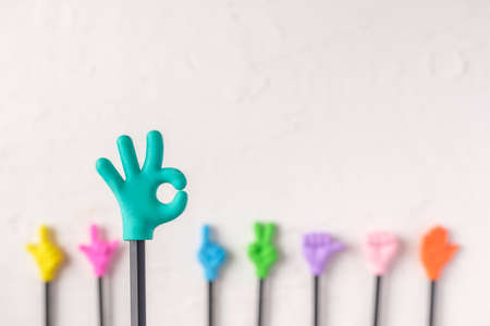 group of toy ok hand gesture on pencil with white paster concrete backgroundの写真素材