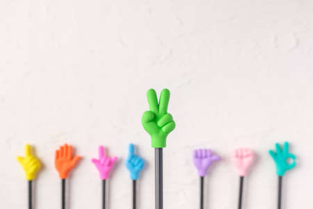 group of toy two finger hand gesture on pencil with white paster concrete backgroundの写真素材