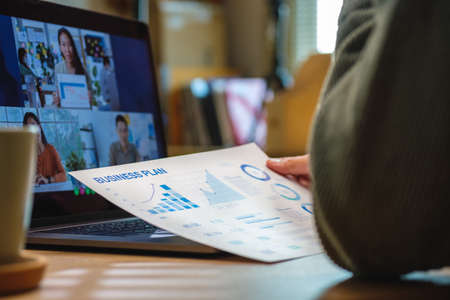 asisn woman video conference busienss meeting with colleage online with laptop at homeの写真素材