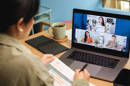 asisn woman video conference busienss meeting with colleage online with laptop at homeの写真素材