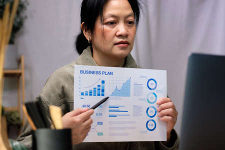 asisn woman presentation business diagram video conference meeting with colleage online with laptop at homeの写真素材