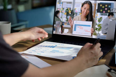 asisn woman video conference busienss meeting with colleage online with laptop at homeの写真素材