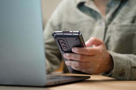 asisn woman use mobile while video conference meeting online with laptop at homeの写真素材