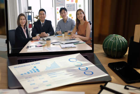 close up screen groupd of asian colleage video confernece business plan with laptop on table at homeの写真素材