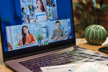 close up screen groupd of asian colleage video confernece business plan with laptop on table at homeの写真素材